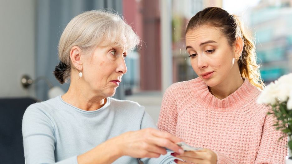 seniorka podaje pieniądze młodszej kobiecie